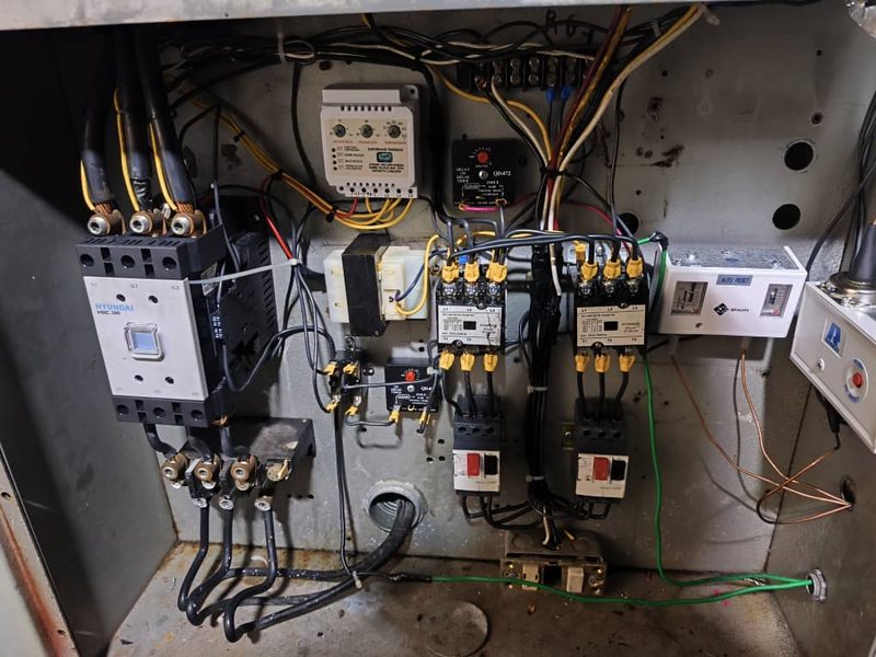 Interior de un tablero eléctrico con contactores, relés térmicos y protector de voltaje, cableado y ordenado.
